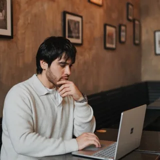 Reece Rainer working on a laptop in a cafe